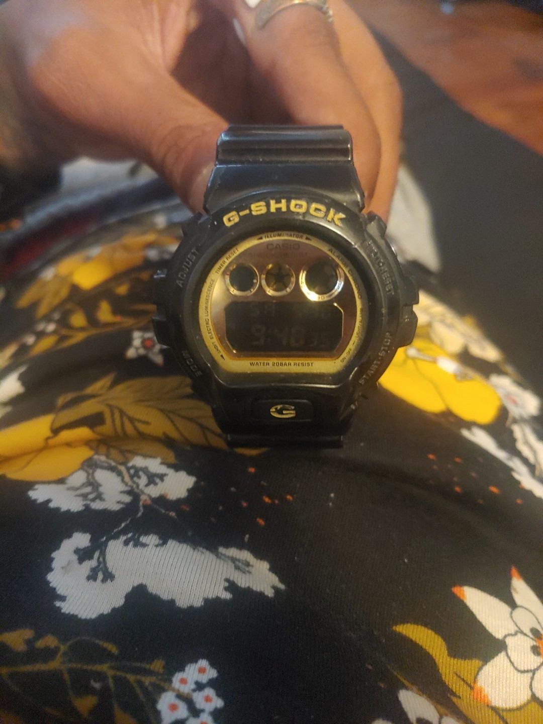 A Casio Watch G Shock 3230 Dwl-6900cb Black And Gold Around The Face Of The Watc